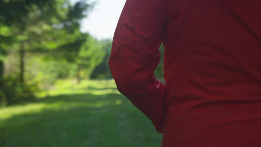 A woman is walking outdoors in a grassland area