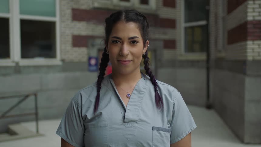 A woman nurse is standing outdoors