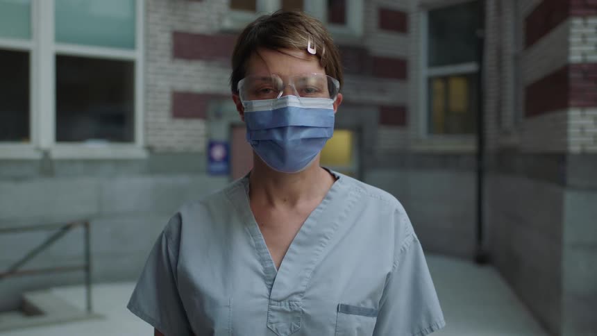 A nurse stands outside a hospital