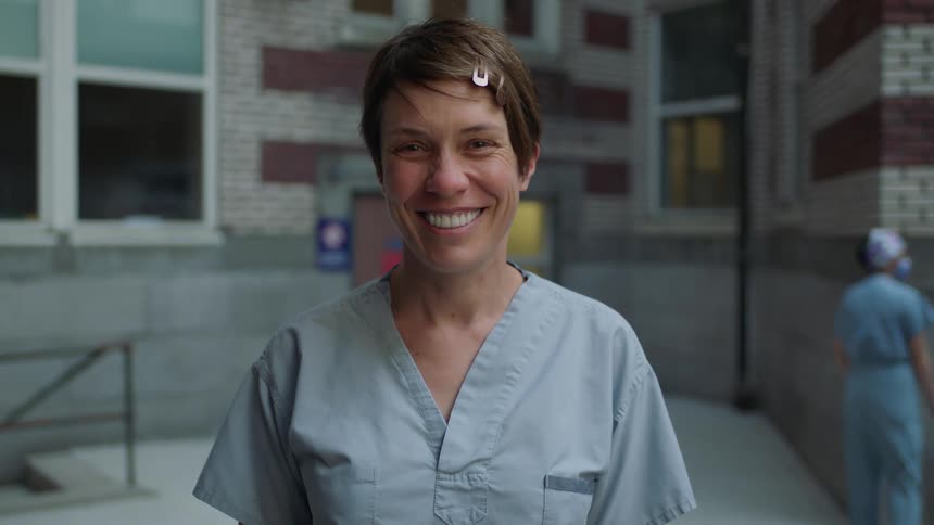 Female nurse raises her head and smiles broadly