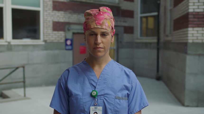 Nurse raises her head and looks at the camera