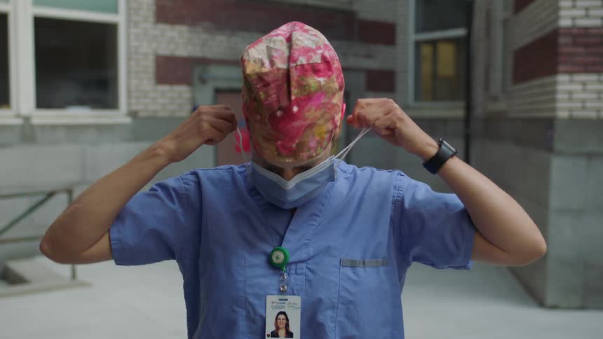 A woman takes off her face mask