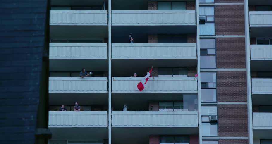 People are waving flags and standing on their balcony