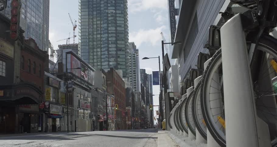 A city street with bicycles people buildings and skyscrapers