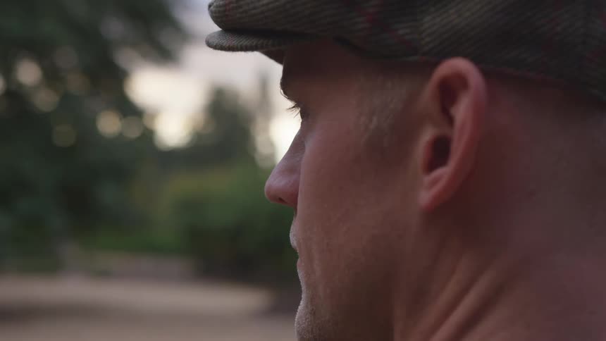 A man is outdoors while wearing a hat