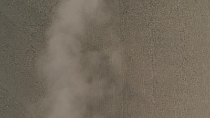 Dust clouds over bare farmland