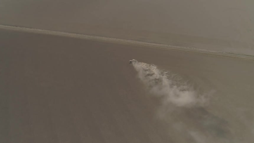 A tractor driving on a field with smoke rising off of it