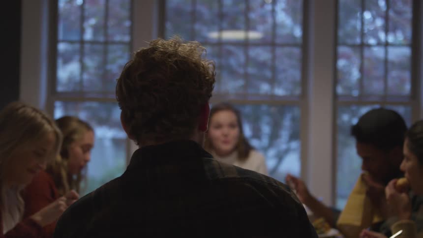 A group of people sit around a dinner table together