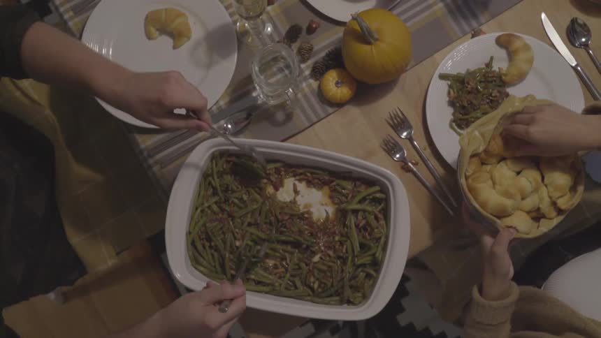 People pass food bowls around and take pieces off and put them on their dinner plate