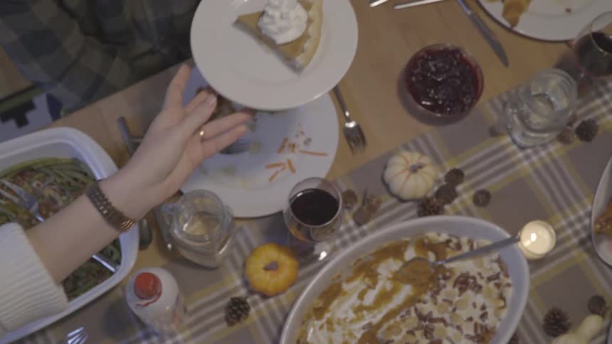 Someone passing pie on a plate after dinner at home