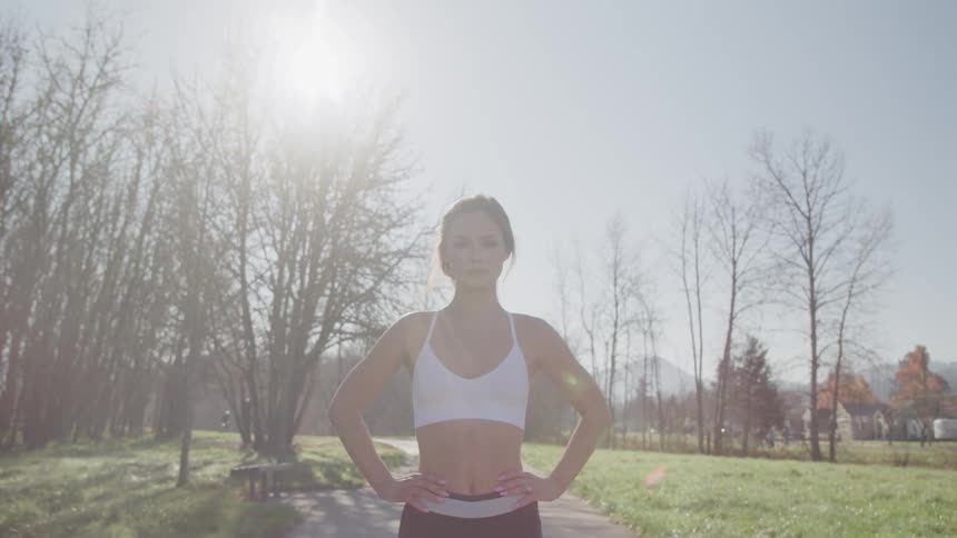 A woman standing on a pathway with trees and the sky in the background