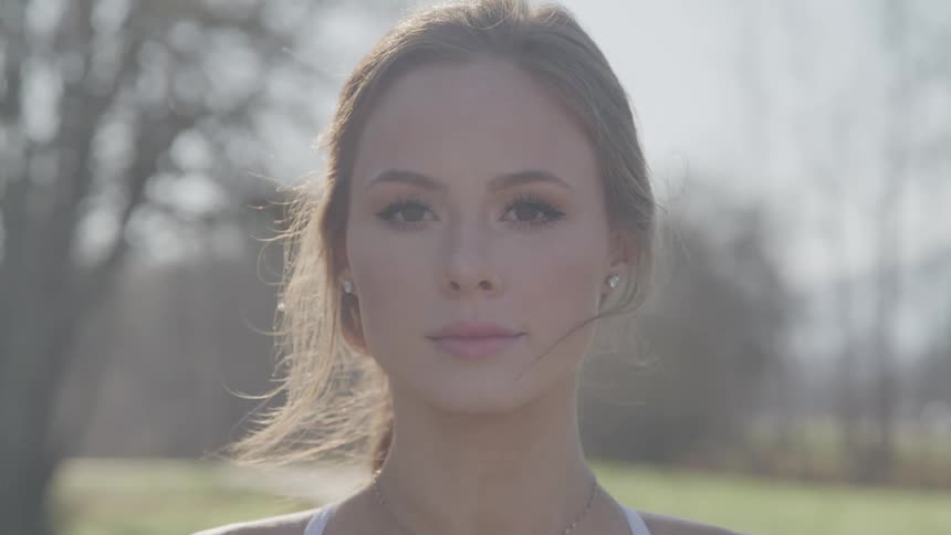Young woman turns to camera and smiles slightly