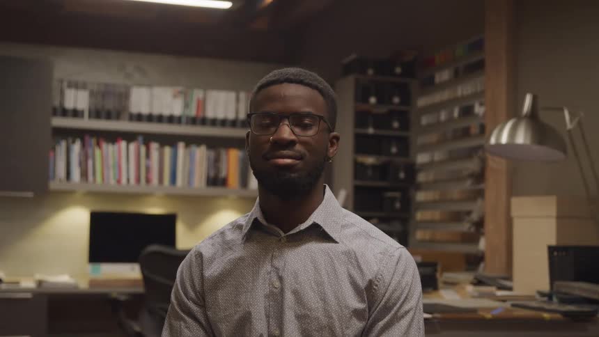 A young man sits in an office space