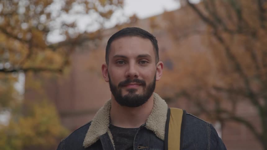 A man is standing outdoors in autumn