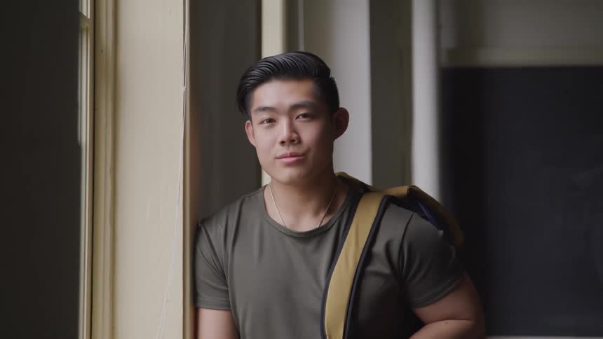 Male college student in empty classroom