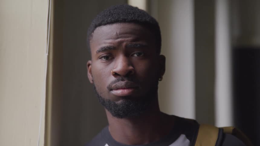 Young black man turns to look at camera