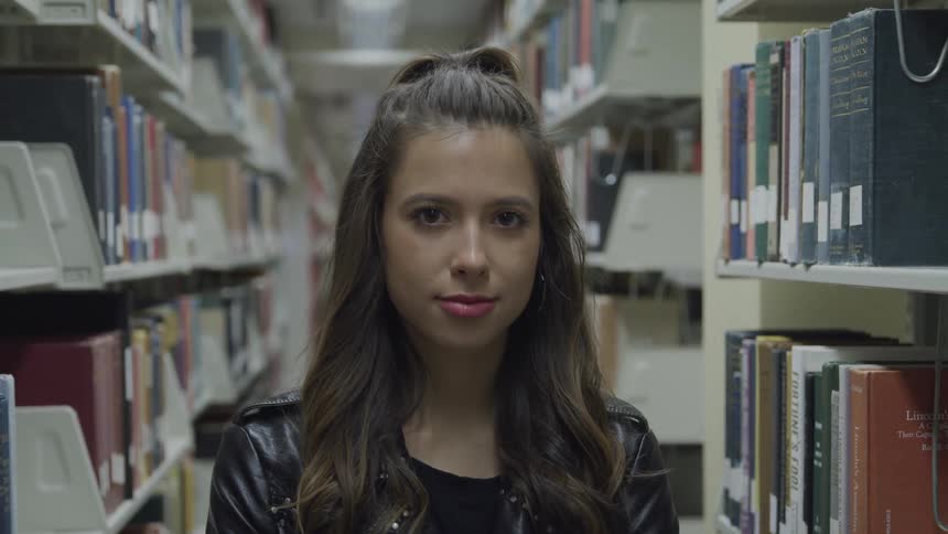A woman is standing inside a library