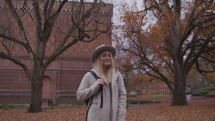 A woman is standing by the building on campus