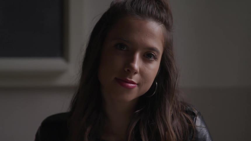 A young woman is wearing a black leather jacket