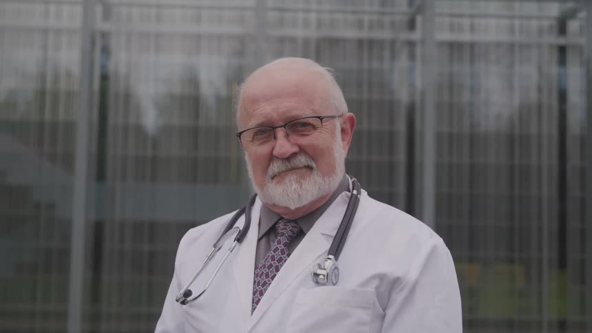 A doctor is standing outside of a building