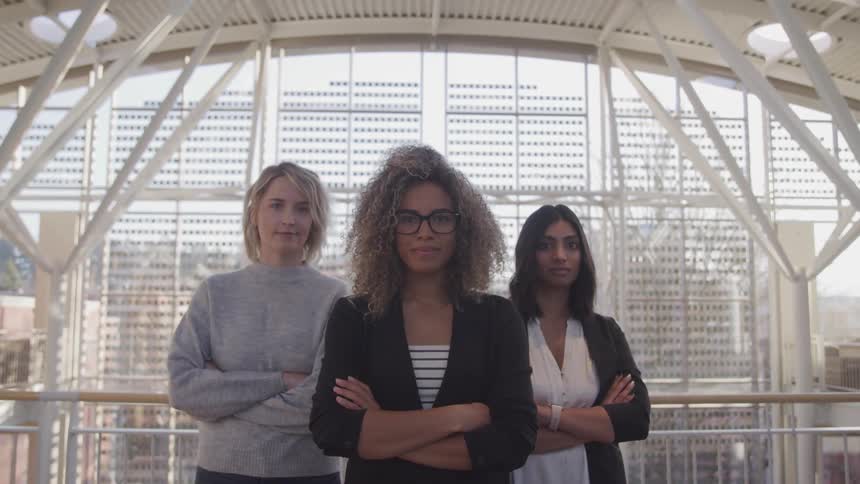 Three women are standing in a building