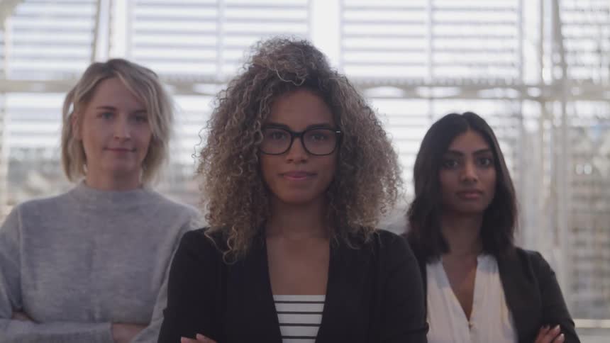 A group of women stand together in an office