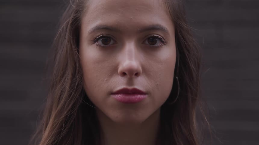 A teenage girl with a neutral expression on her face looks ahead
