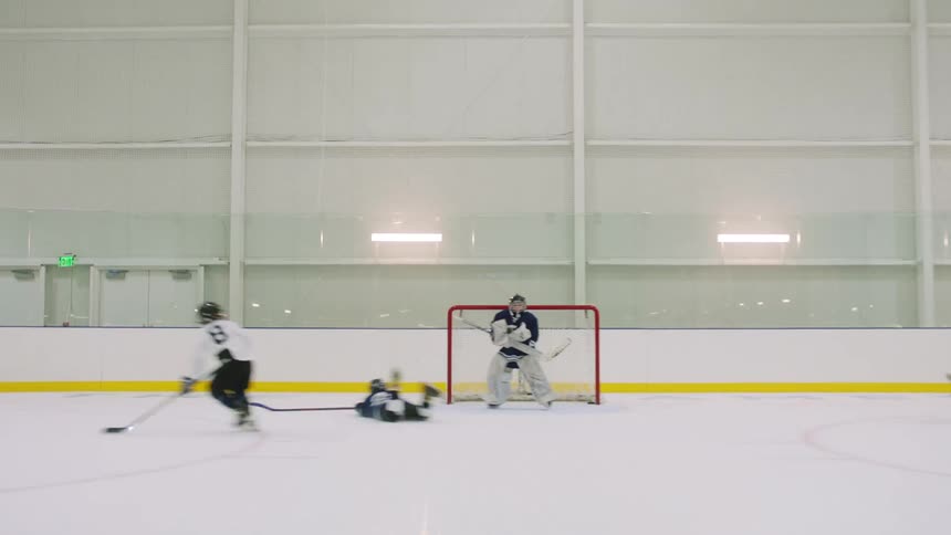 Children playing hockey on indoor ice rink