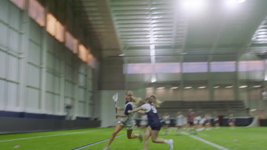 A group of women play indoor lacrosse