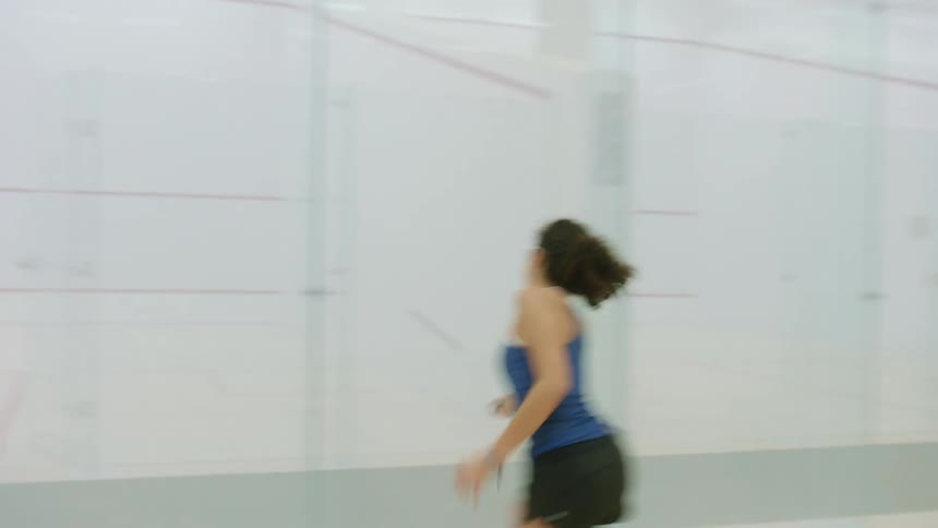 A man and woman play indoor racket ball together