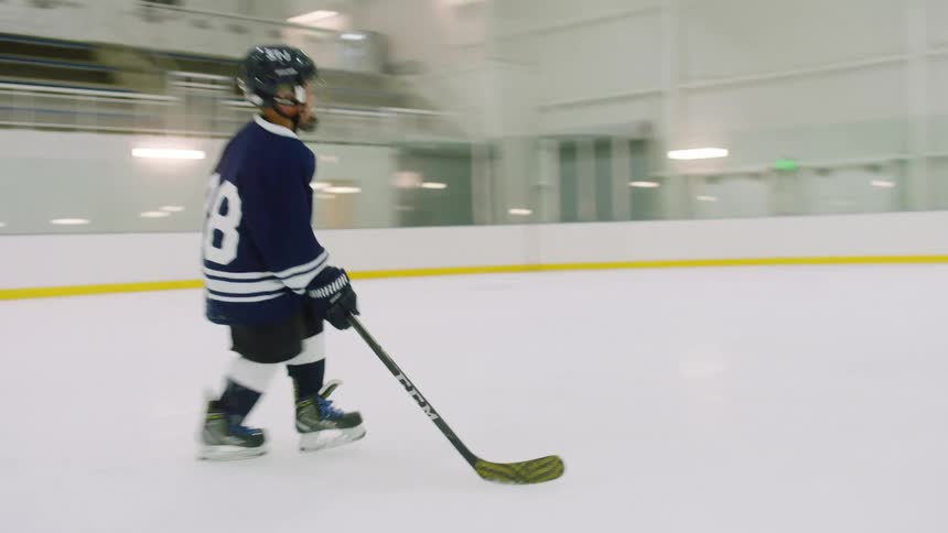 Young boy does hockey practice on an ice rink inside a stadium