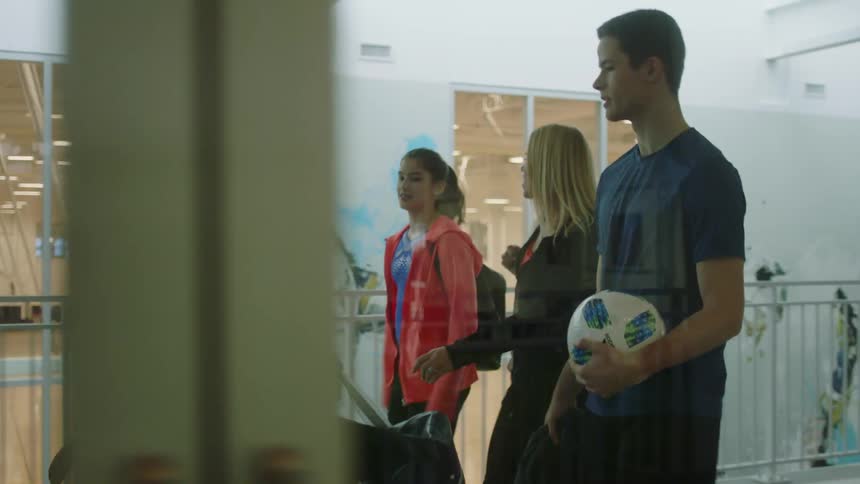 A man a woman a boy and a girl walking with a gym in the background
