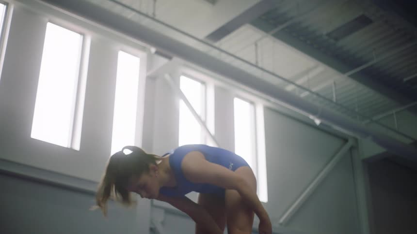 A young girl spins around as she practices gymnastics