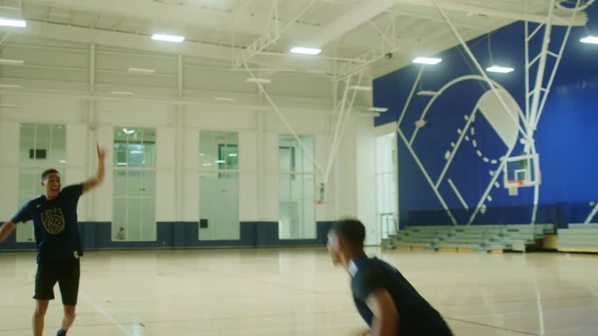 A group of people play indoor basketball and celebrate a throw