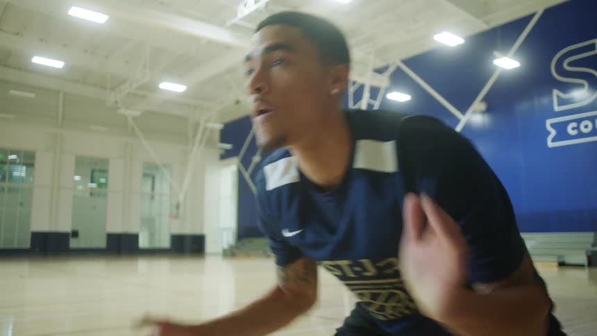 Young man in an indoor basketball court gets ready for practice