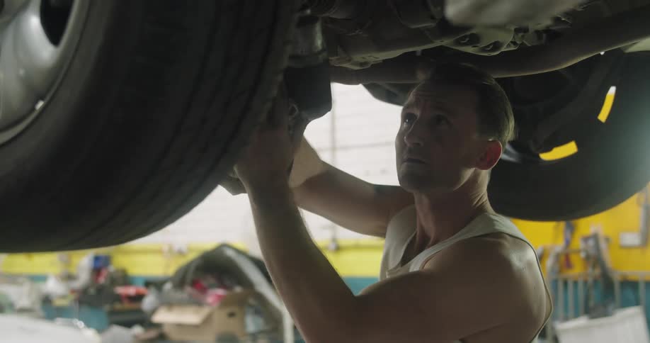 Man works on car in auto shop