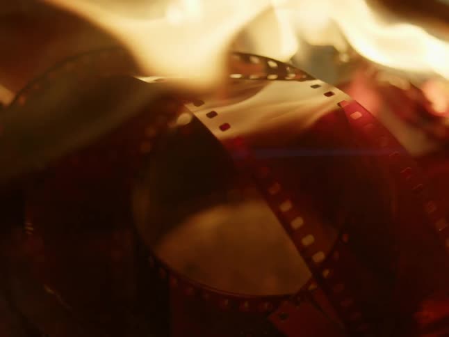 Plastic strips of camera film are set on fire and burn