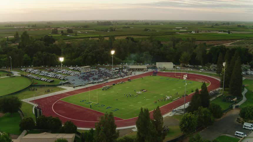 Audience occupies bleachers on both side of the football field