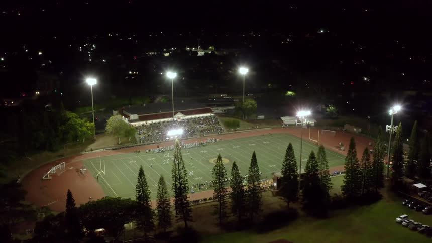 An aerial view of a crowd watching a football game in a stadium