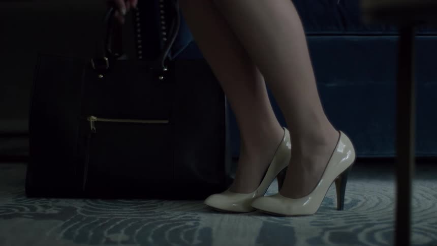 A woman picks a bag up off the floor