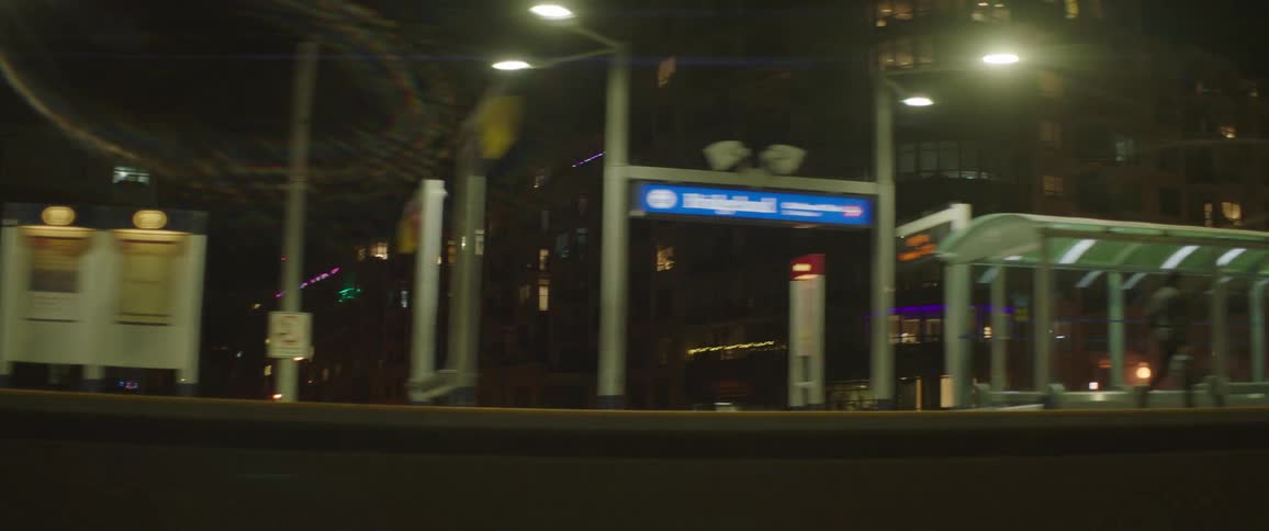 An outdoor train terminal in a metropolis at night