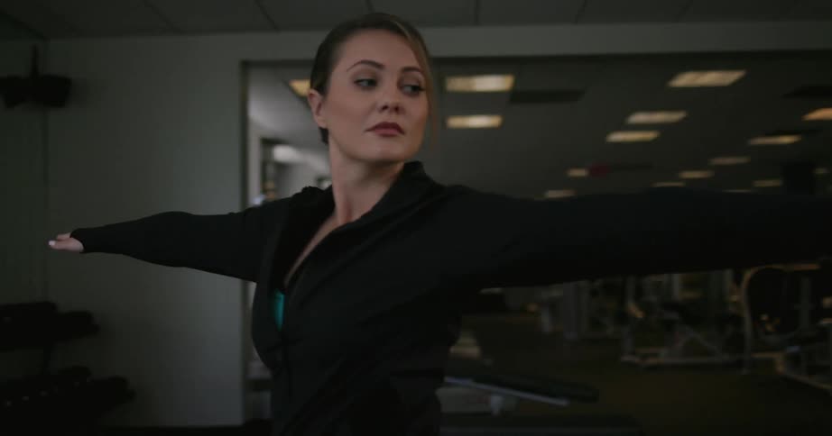 A woman practices yoga in a gym
