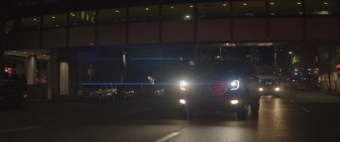 Vehicles driving down a city street at night