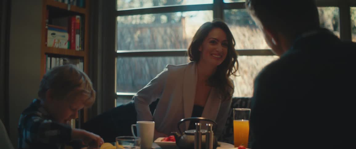 A family sits together at a table with food and drink