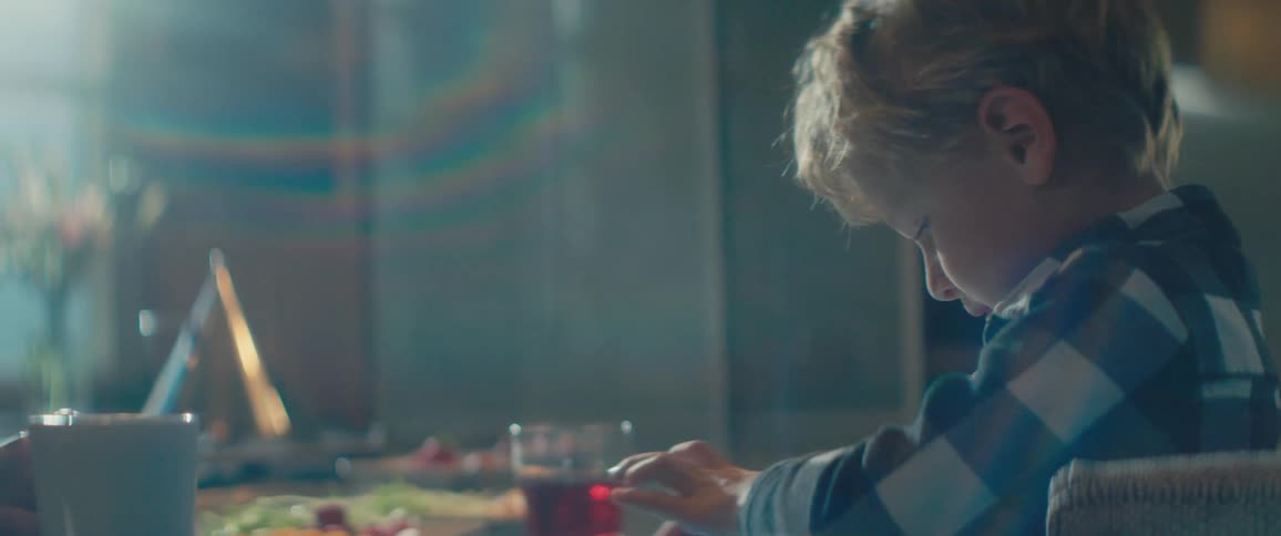 Boy uses a tablet while sitting at the diner table at home