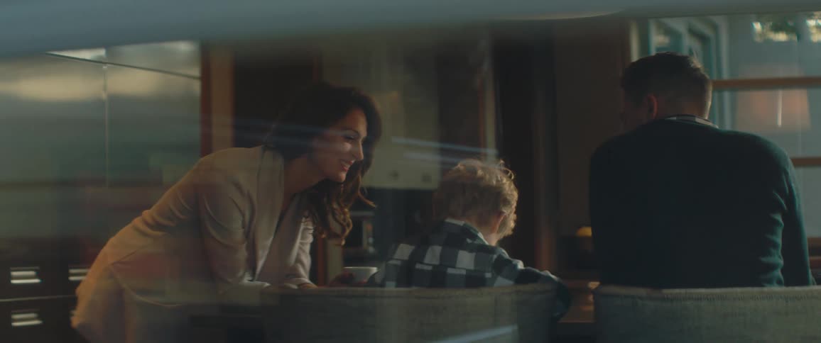 Mother and father talking with young son at kitchen table