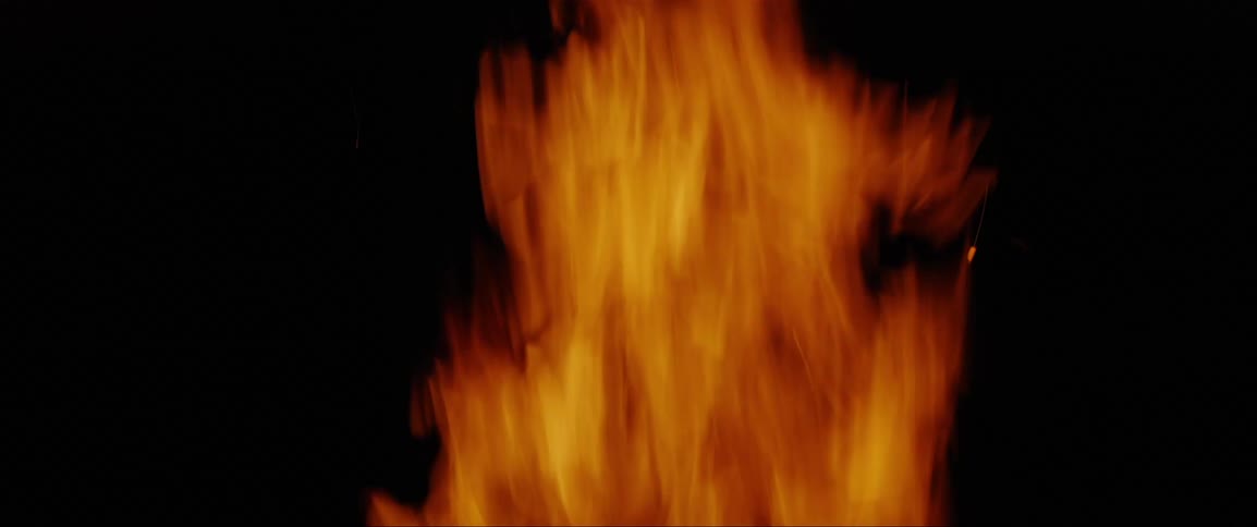 A fire is burning outdoors at night