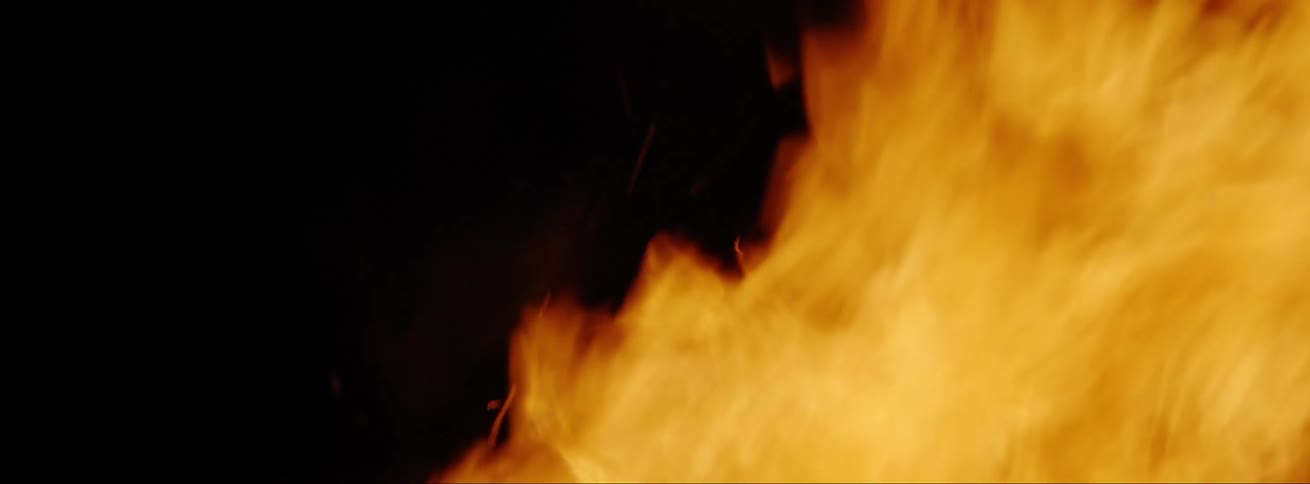 Close up of bright yellow and orange flames at night