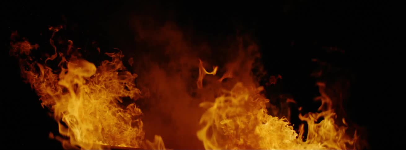 Bright yellow and orange flames smoking on a black background