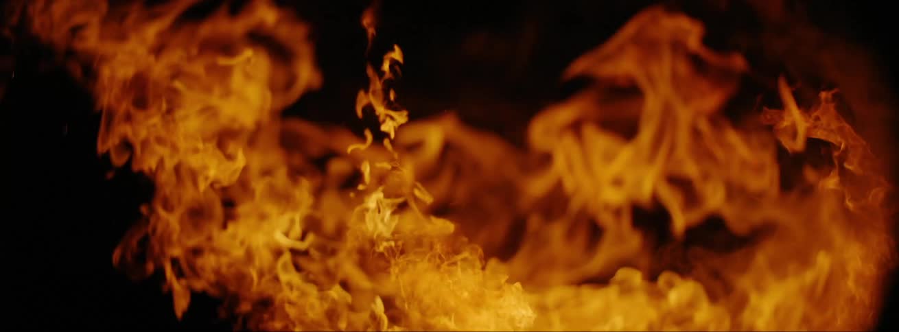 A bonfire is burning outdoors at night